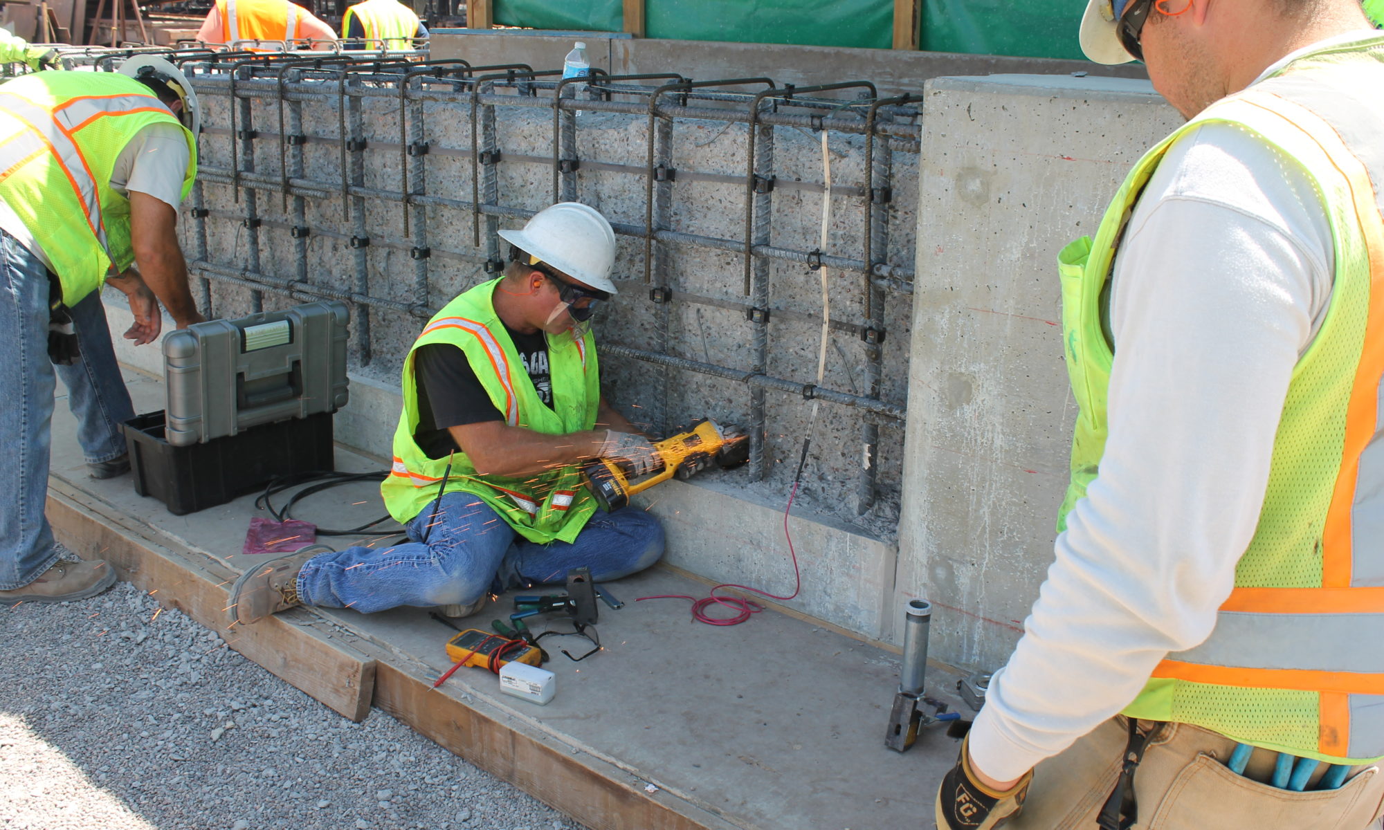 Construction worker inspecting rebar on a concrete structure.