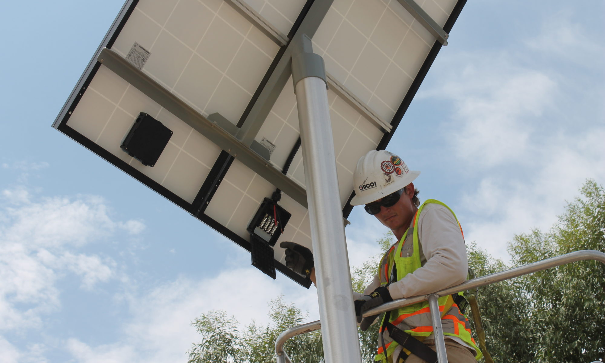 Technician inspecting the underside of a solar panel outdoors.